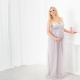 pamiątkowa sesja zdjęciowa z ciążowym brzuszkiem - przyszła mama blondynka w pięknej sukni stoi przy kominku